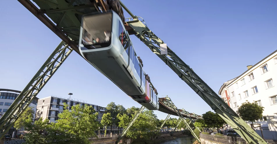 Die Wuppertaler Schwebebahn fliegt durch das grüne Tal