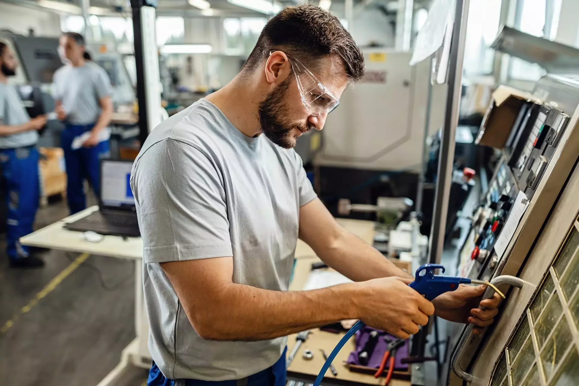 QM-Mitarbeiter an einer Maschine in der Produktionshalle