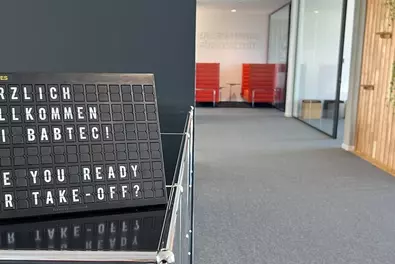 Eingangsbereich des Frankfurter Büros mit Buchstabentafel "Herzlich willkommen bei Babtec. Are you ready for Take-off?"