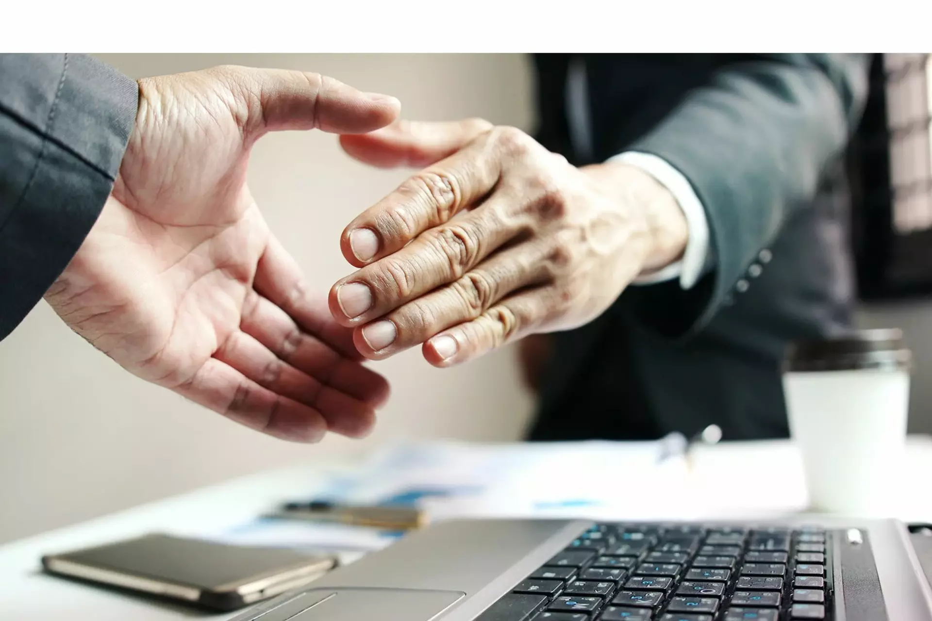 Nahaufnahme zweier Menschen, die sich die Hand reichen