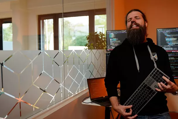 Kollege aus der IT mit Gitarre in seinem Büro