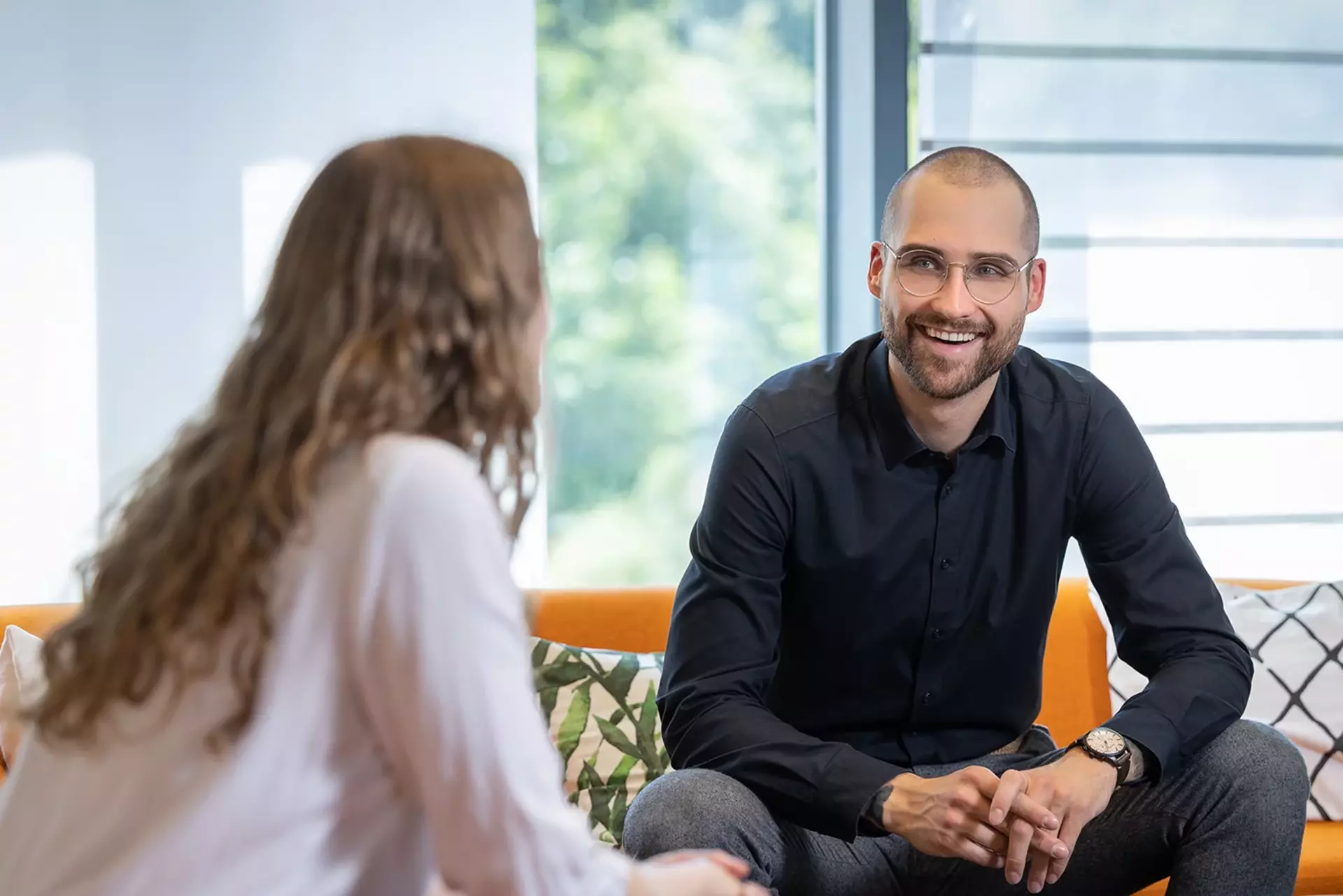 Babtec-Mitarbeitende sitzen auf dem Sofa im Büro und unterhalten sich