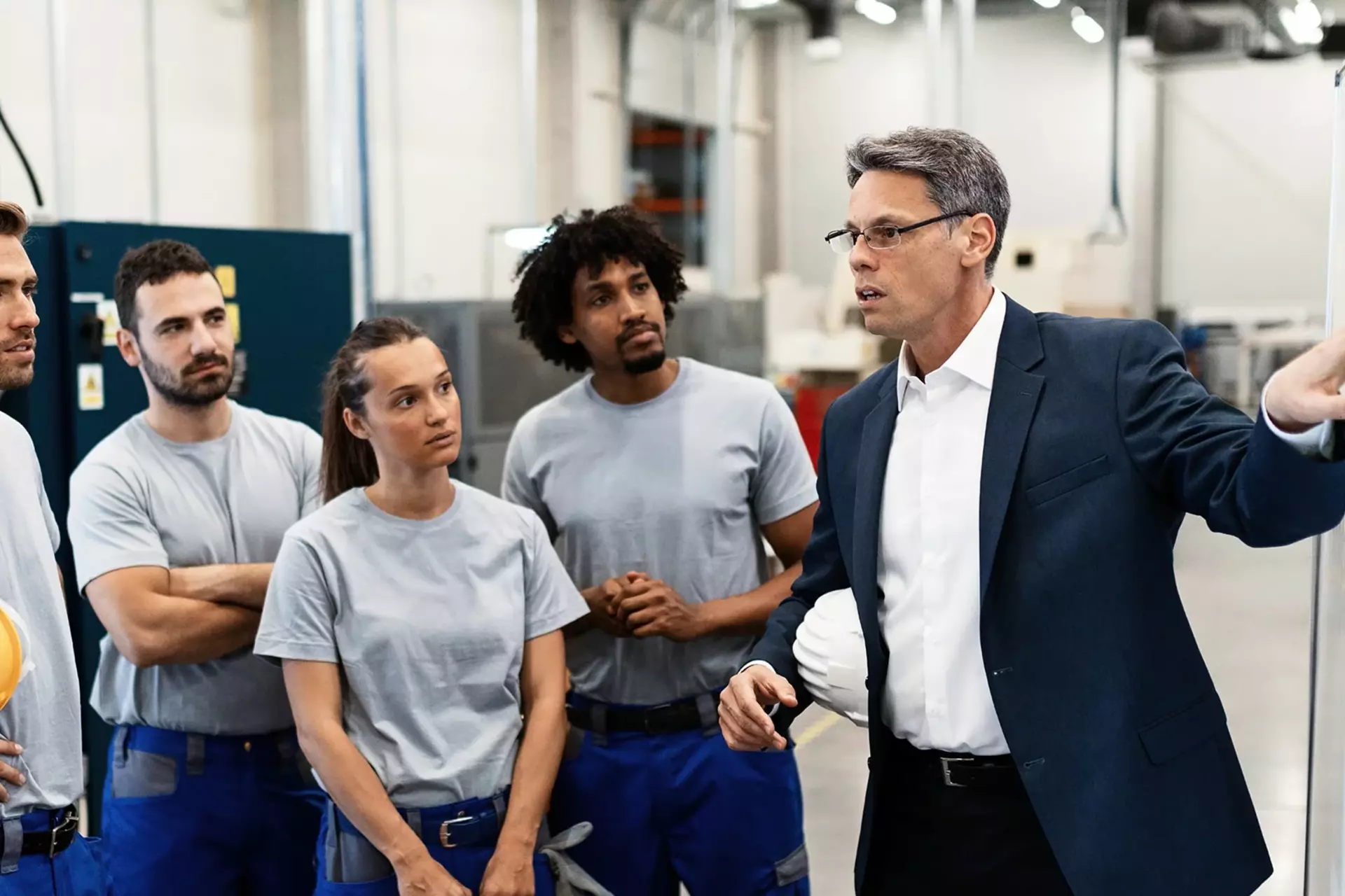 Teamleiter instruiert sein Team in der Produktionshalle